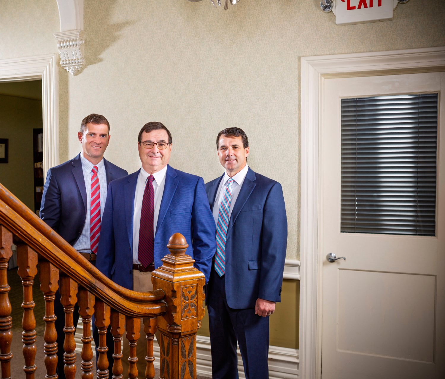 Business Attorneys John D. Miller Jr., Andrew J. Miller, and Christian R. Miller Standing Near Stairwell